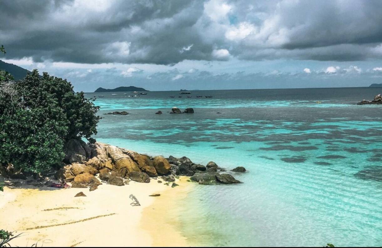 Secluded turquoise cove with rocky headlands and golden sand, hidden Khanom–Sichon coastline.